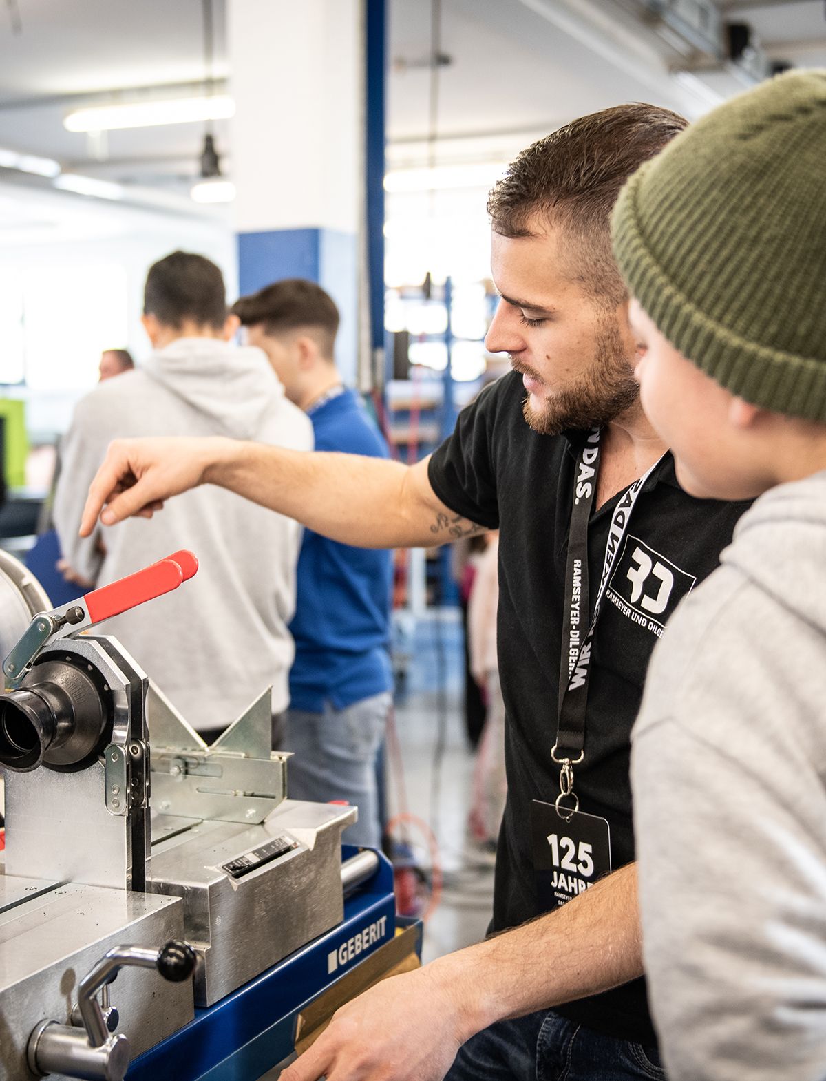 Mitarbeiter Ramseyer und Dilger zeigen dem Nachwuchs eine Maschine